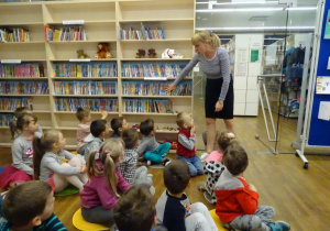 Pani bibliotekarka pokazuje dzieciom bibliotekę
