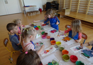 Dzieci malują obrazek misia na szkle