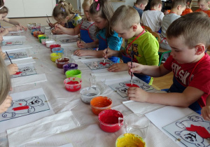 Dzieci malują farbami obrazek misia na szkle