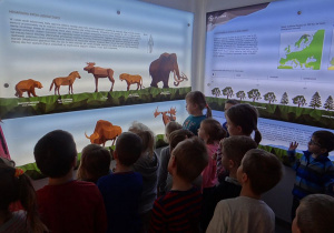 Dzieci oglądają zwierzęta Epoki Lodowcowej.