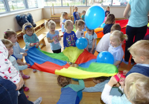 Dzieci podrzucają baloniki na chuście
