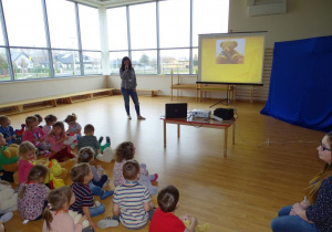 Dzieci poznaja historię pluszowego misia oglądając prezentację