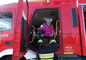 Dziewczynka z grupy trzylatków w wozie strażackim