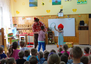 Dzieci z klaunem robią pokaz