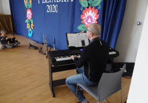 Pan Wojtek gra na przedszkolnym pianinie.