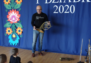 Pan Wojtek pokazuje dzieciom zabytkową waltornię.