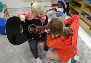 Iza uczy Lilę chwytu gitarowego.