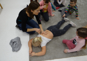 Pani Ania pokazuje dzieciom, w jaki sposób masować drugą osobę.