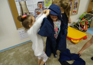 Lena pomaga Natalii założyć kurtkę.