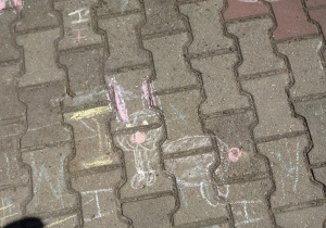 Królik narysowany kredą na chodniku.