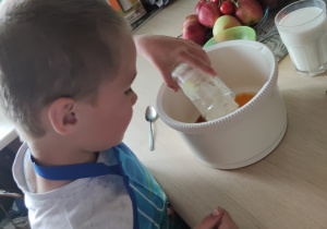 Daniel wsypuje mąkę do miski.