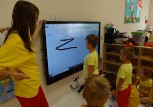 Dzieci piszą znak Zorro na tablicy.